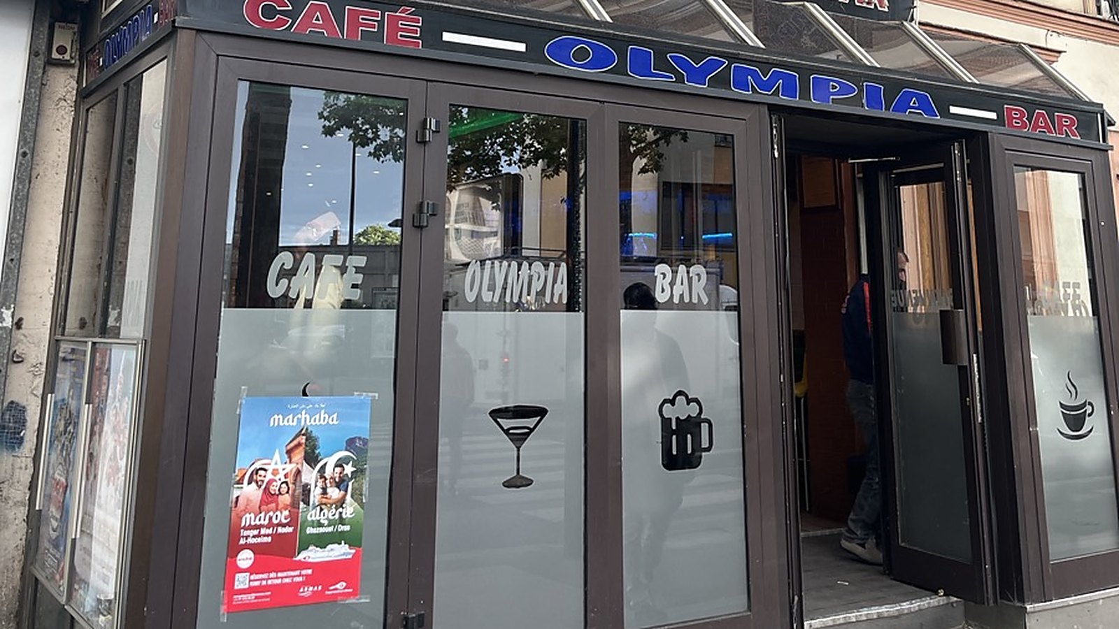 Affiche A3 d'une campagne collée côté rue sur la vitre d'un café bar à Aubervilliers, sous l'enseigne du commerce