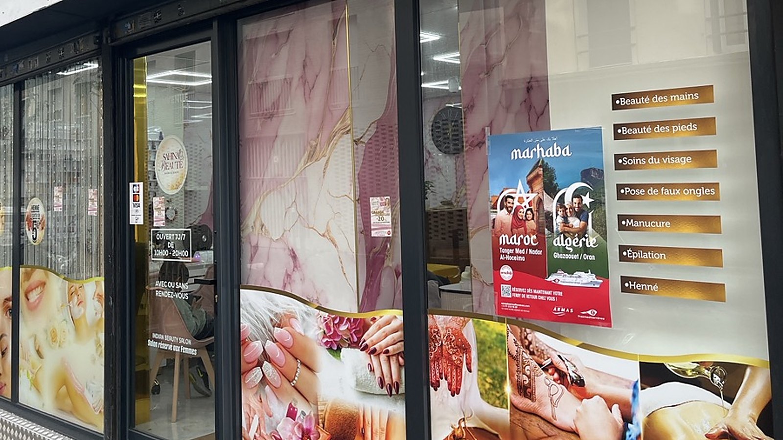 Affiche A3 d'une campagne collée sur la vitrine d'un salon de beauté à Saint-Denis, à côté de la liste des prestations