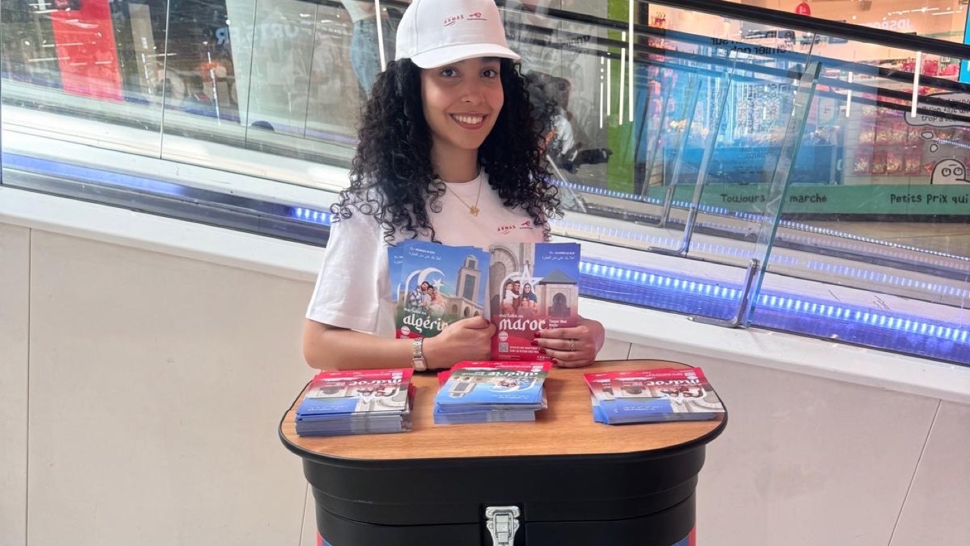Animatrice en stand avec des brochures dans la galerie d'un centre commercial