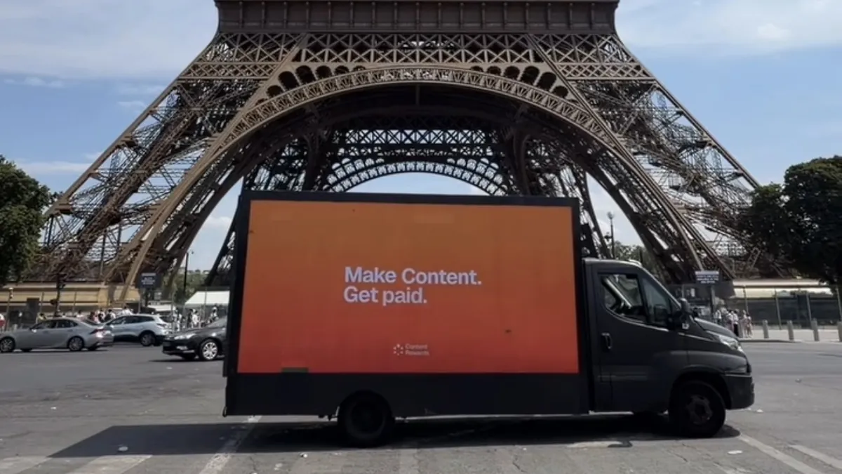 Camion publicitaire LED affichant la campagne Content Rewards au pied de la tour Eiffel, à Paris