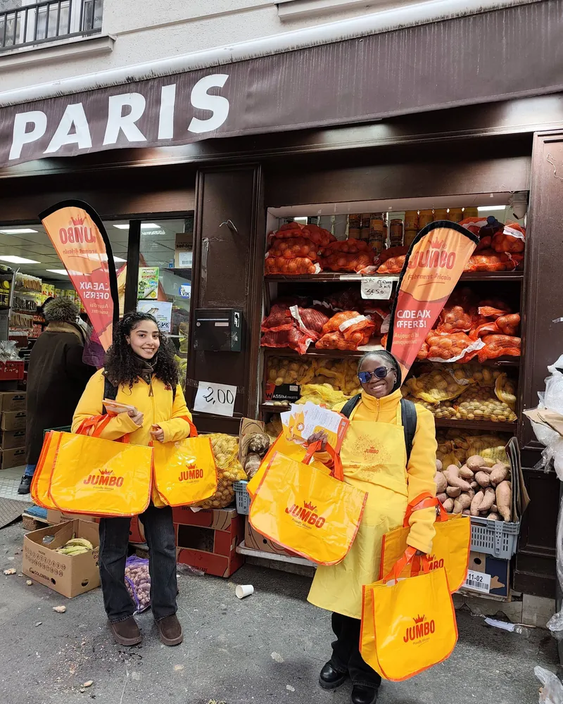 Deux animatrices Strevoo en tenue jaune Jumbo distribuant des sacs et des flyers devant une épicerie à Paris