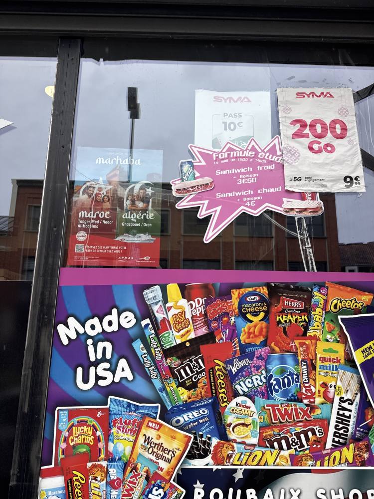 Affiche de la campagne Trasmediterránea posée sur une vitrine à Roubaix