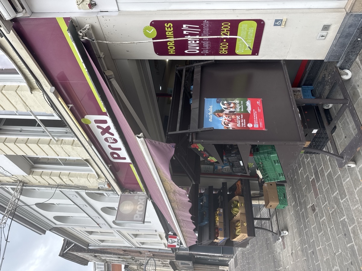 Affiche posée en vitrine d'une épicerie près de la Grand-Place à Tourcoing